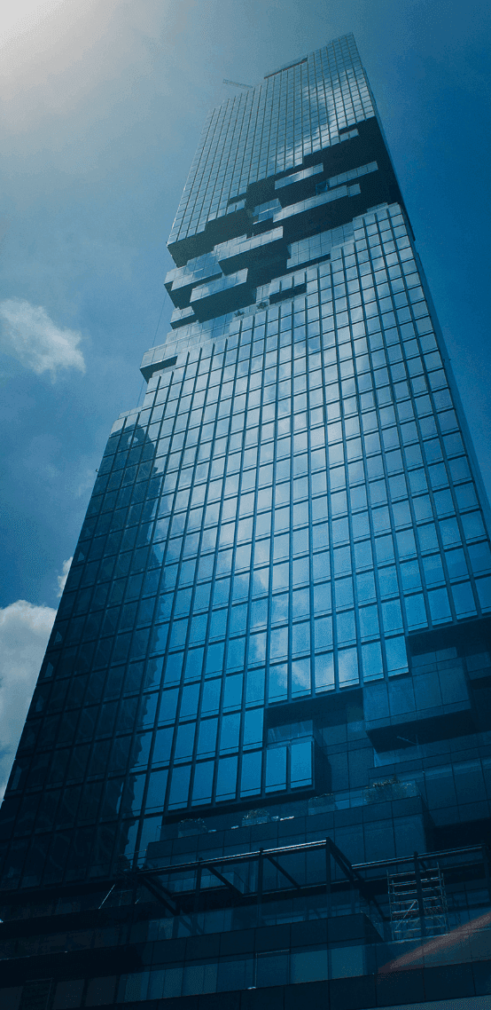Tall, modern glass skyscraper with a unique pixelated facade against a bright blue sky.